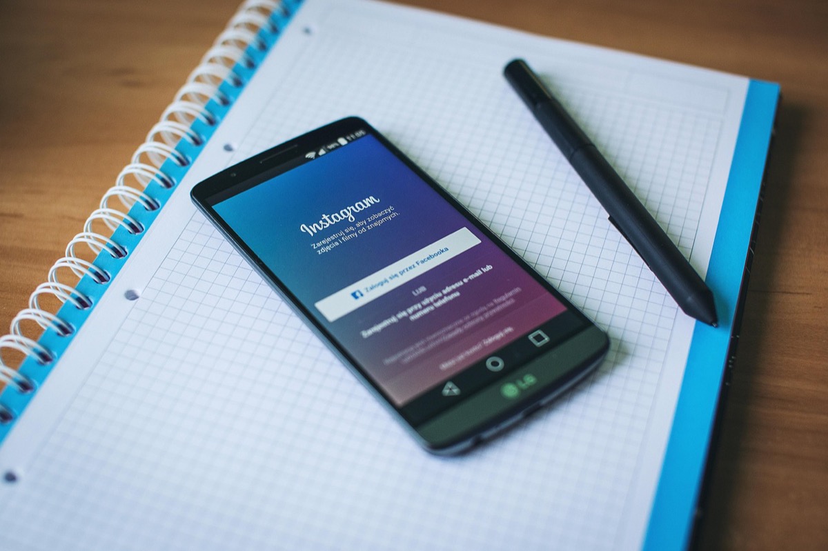 Smartphone affichant Instagram posé sur un bureau de travail, illustration de la difficulté à faire des vues sur les réseaux sociaux