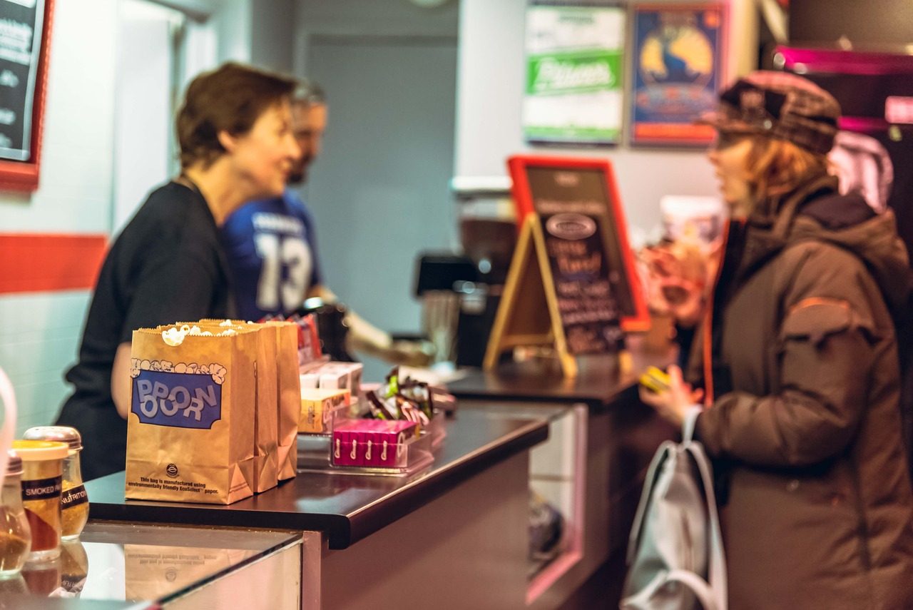 Commerçante servant une cliente derrière le comptoir de sa boutique