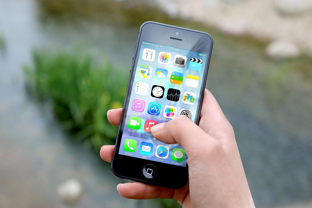 Main tenant un smartphone, illustration d'un créateur qui consulte ses vues bloquées sur les réseaux sociaux