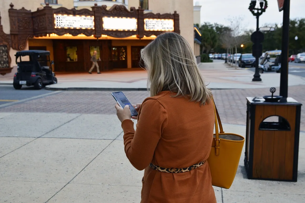 Jeune femme utilisant son smartphone pour filmer une vidéo verticale en intérieur, format authentique et spontané typique de TikTok